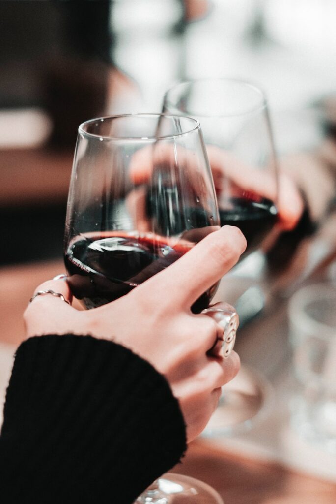 person holding clear wine glass