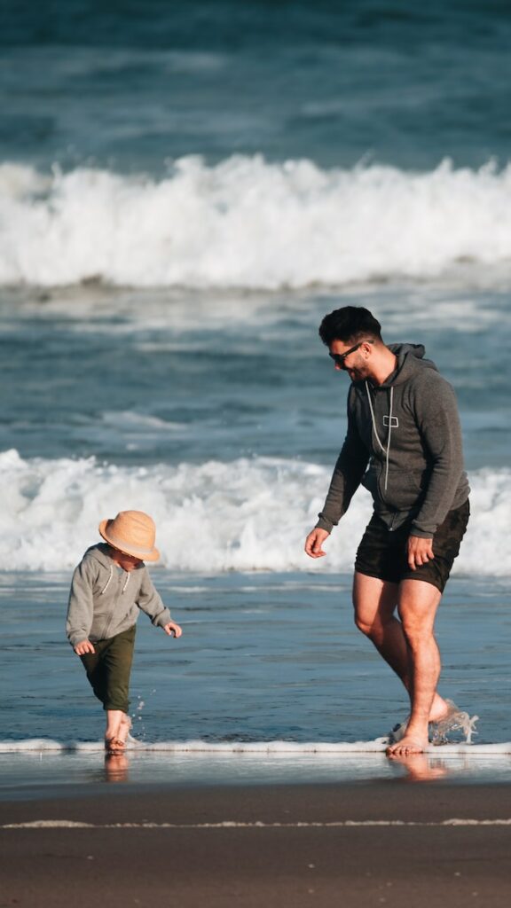 a man and a child are playing on the beach