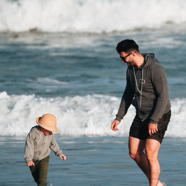 a man and a child are playing on the beach