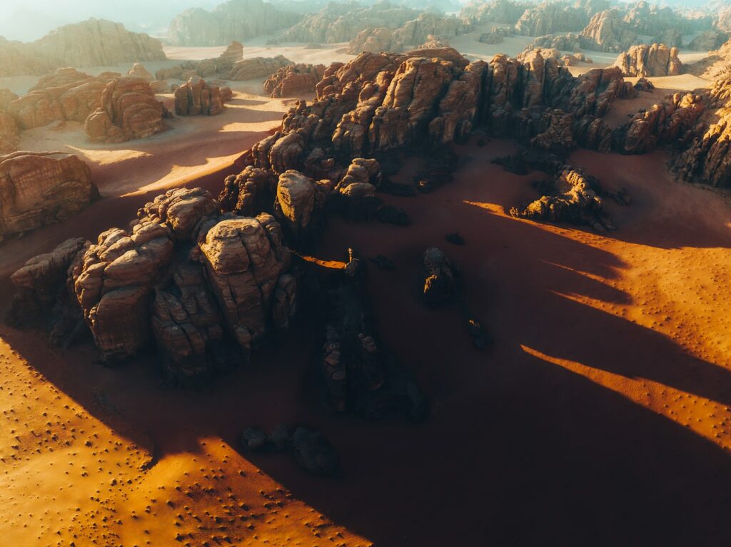 an aerial view of a desert with rocks and sand