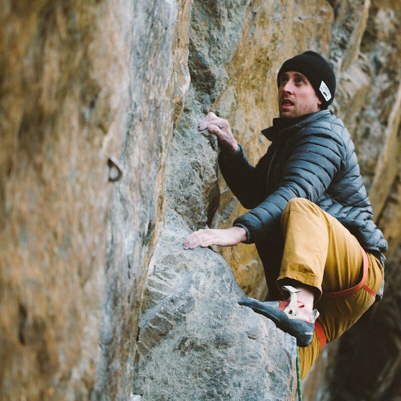 a man climbing up the side of a mountain