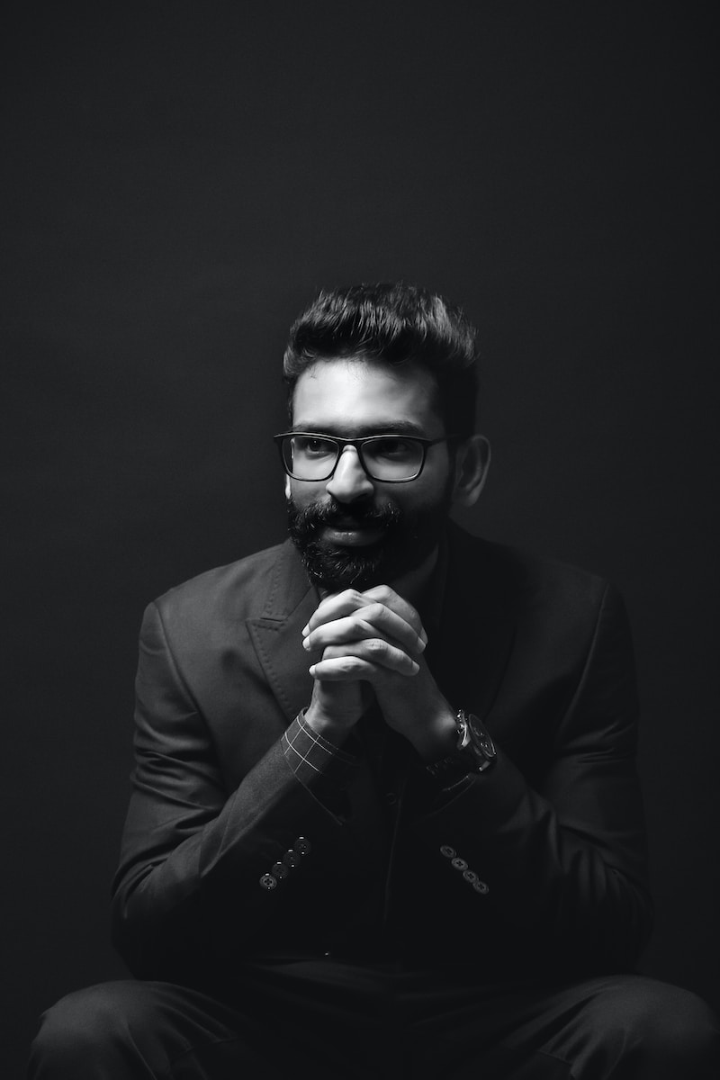 Photo by Nith IN grayscale photography of sitting man wearing suit