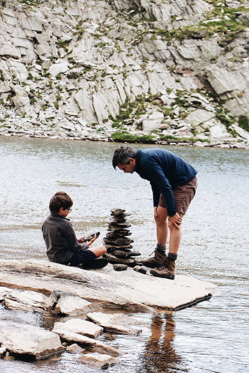 Photo by Maël BALLAND boy and man beside river during daytime