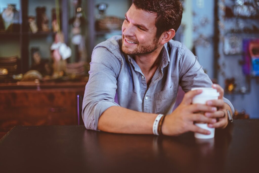 man holding cup on table