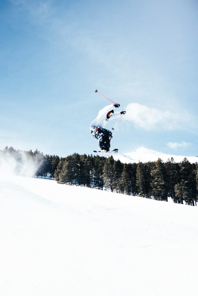 A man flying through the air while riding a snowboard