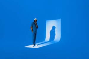 A man casts a shadow on a blue background.