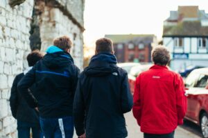 man in black jacket standing beside woman in red hoodie