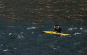a man and a woman on a yellow surfboard in the water