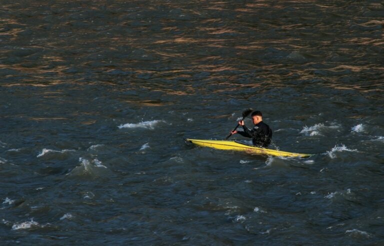 a man and a woman on a yellow surfboard in the water