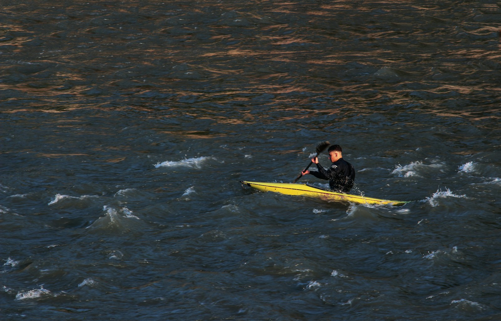a man and a woman on a yellow surfboard in the water